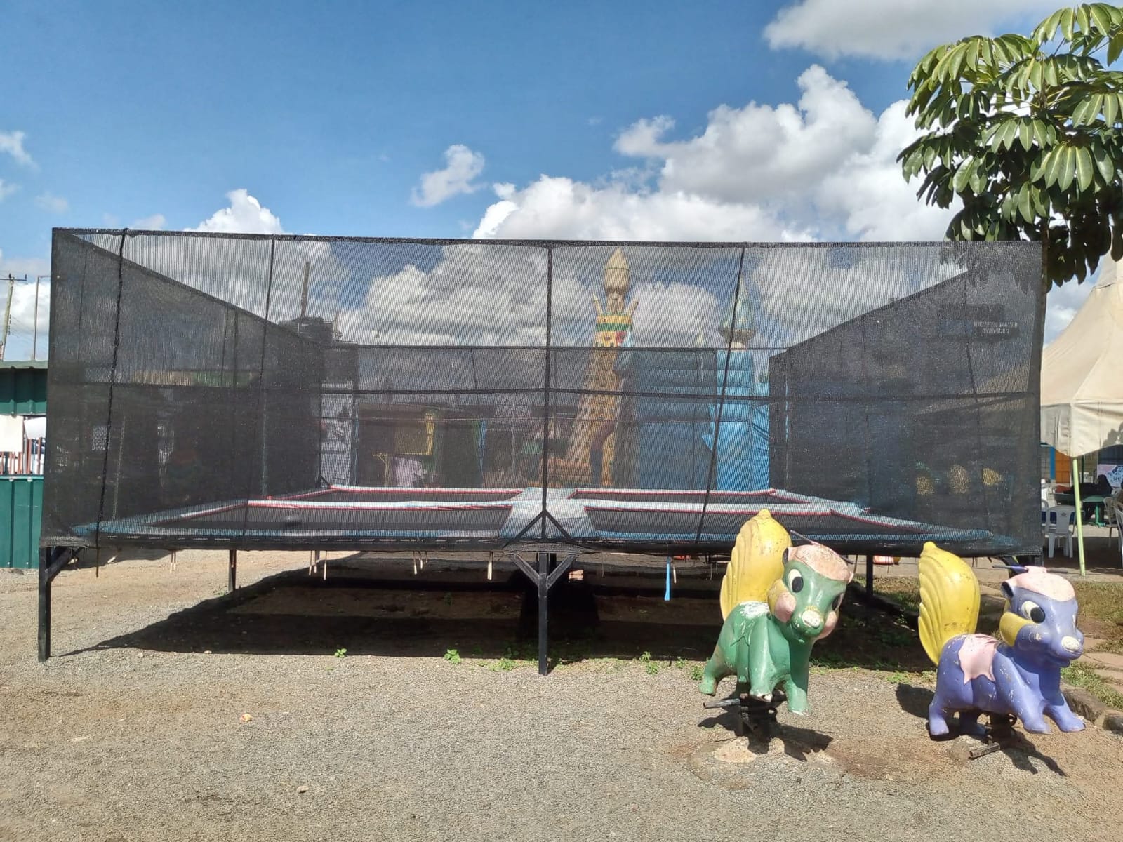 A large netted trampoline beside colourful spring rockers at Vipe Fun Park