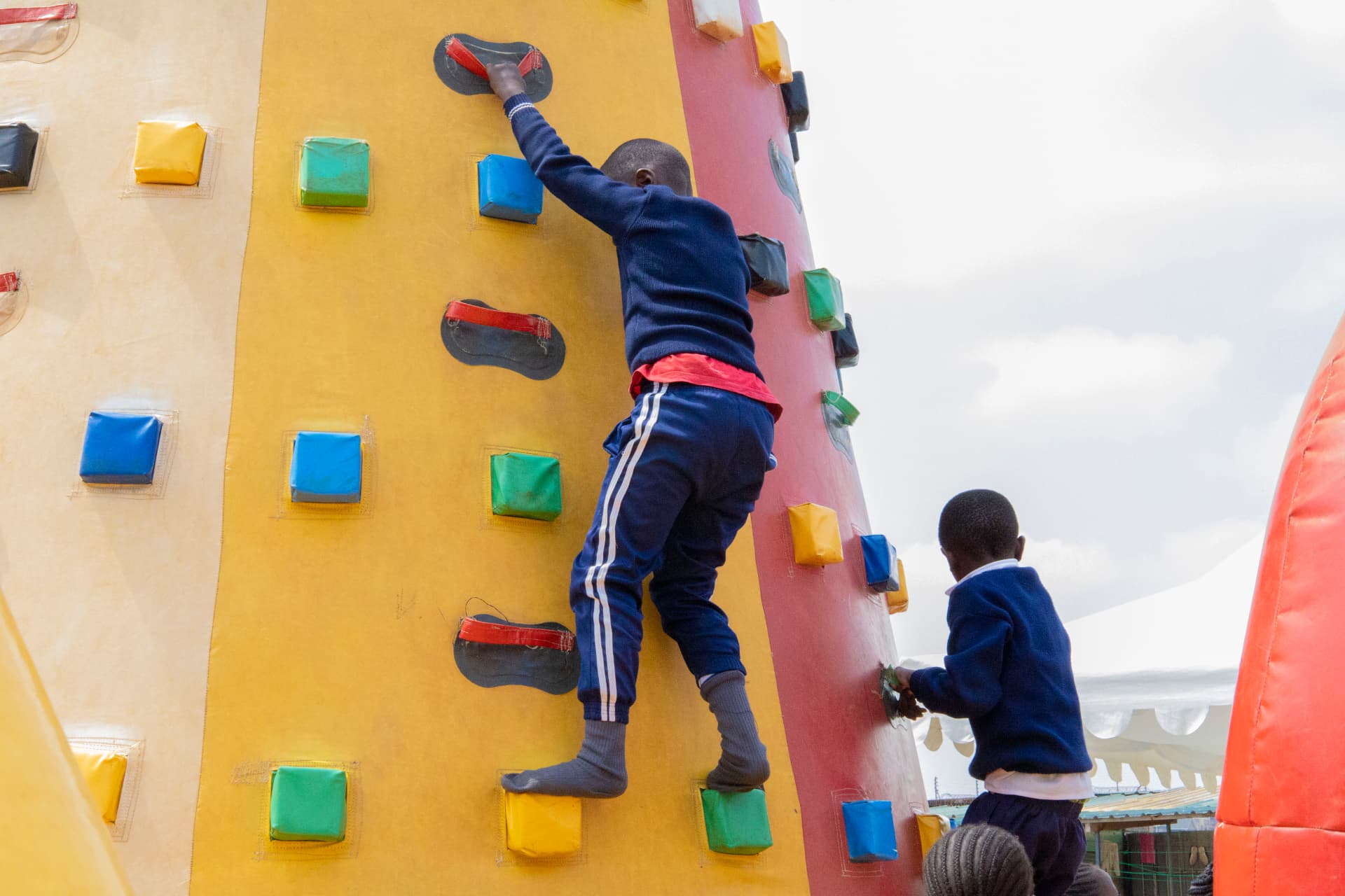 A child photographed from behind climbing the colourful inflatable tower