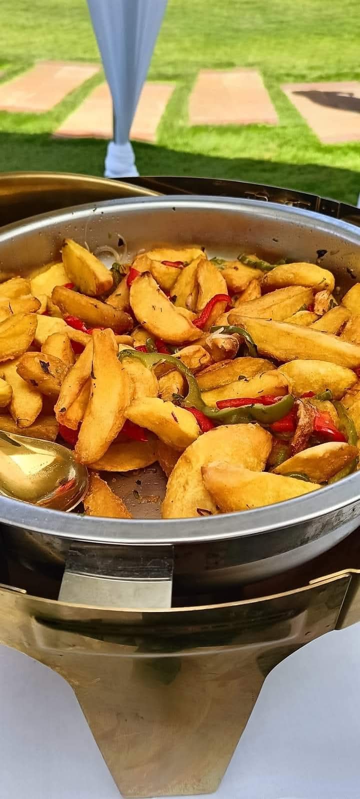 Potato wedges with red and green peppers in a warming dish on the lawn at Vipe Fun Park