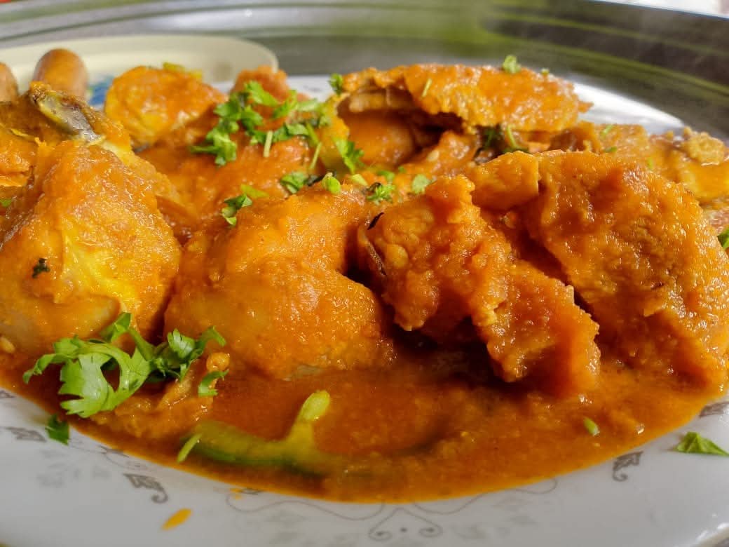 A plate of chicken in rich tomato sauce garnished with coriander, served at Vipe Fun Park