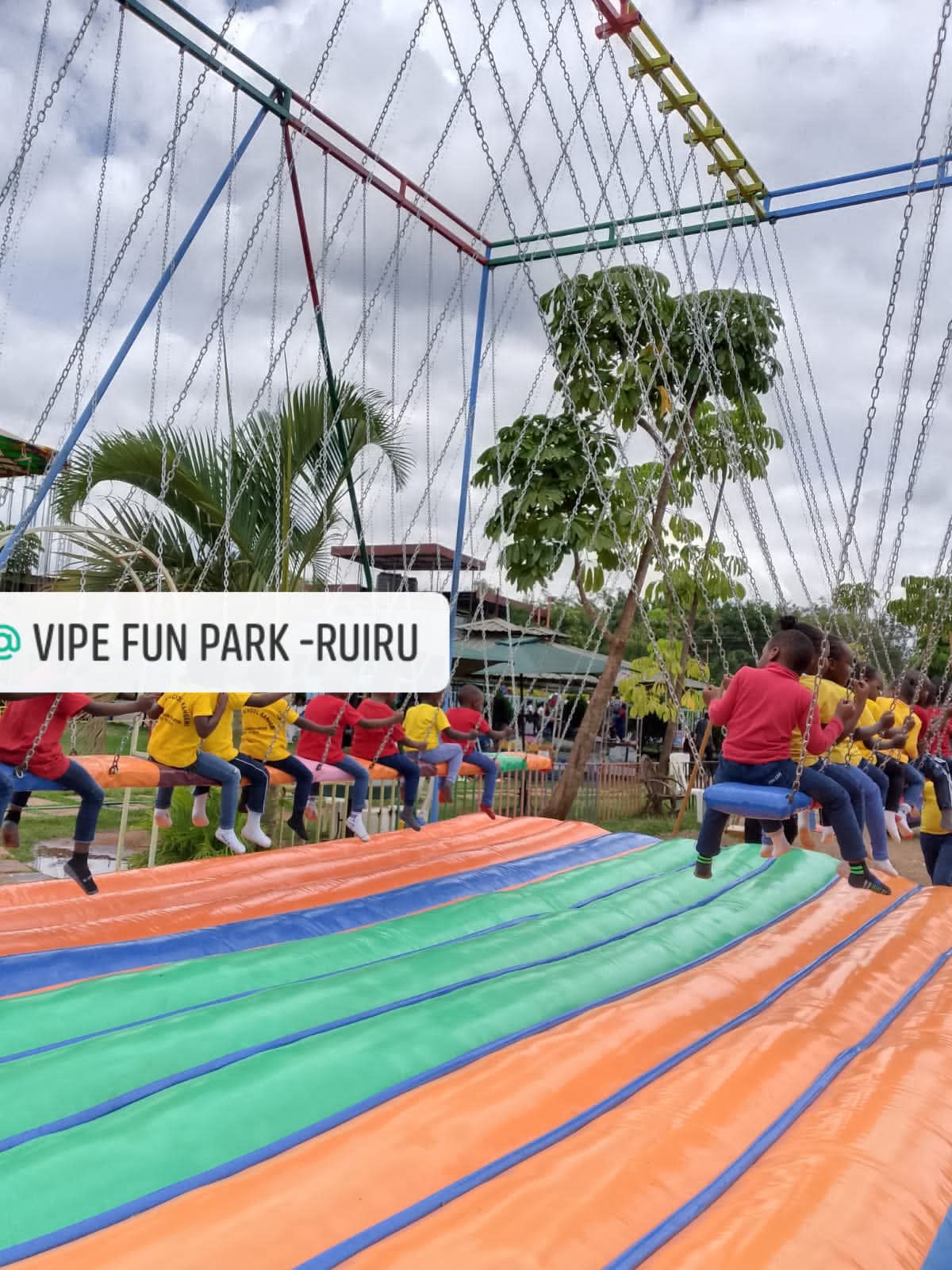 School children photographed from behind on the chain swing ride at Vipe Fun Park in Ruiru