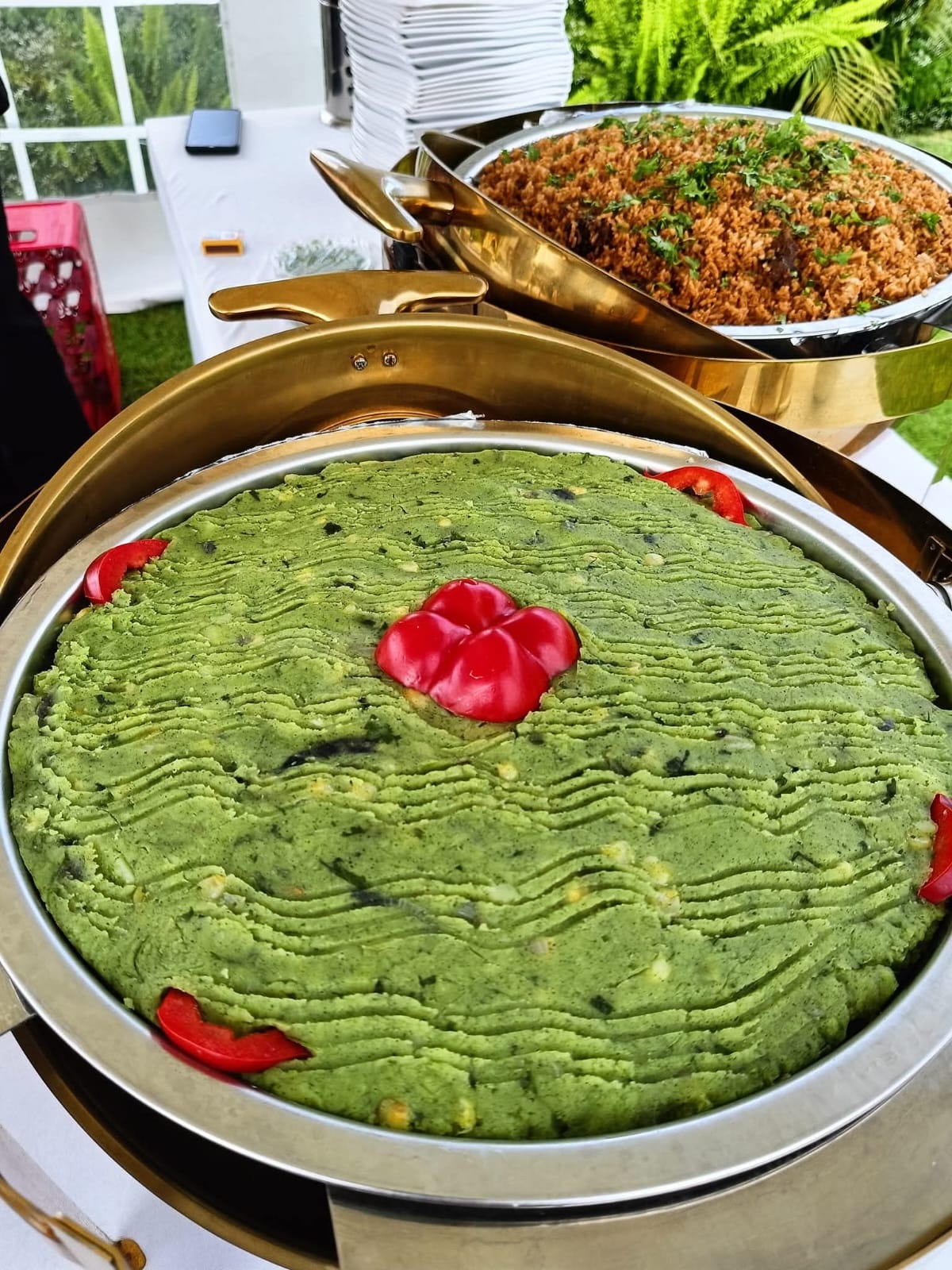 A dish of mashed greens and potatoes garnished with red pepper, served beside spiced rice at Vipe Fun Park