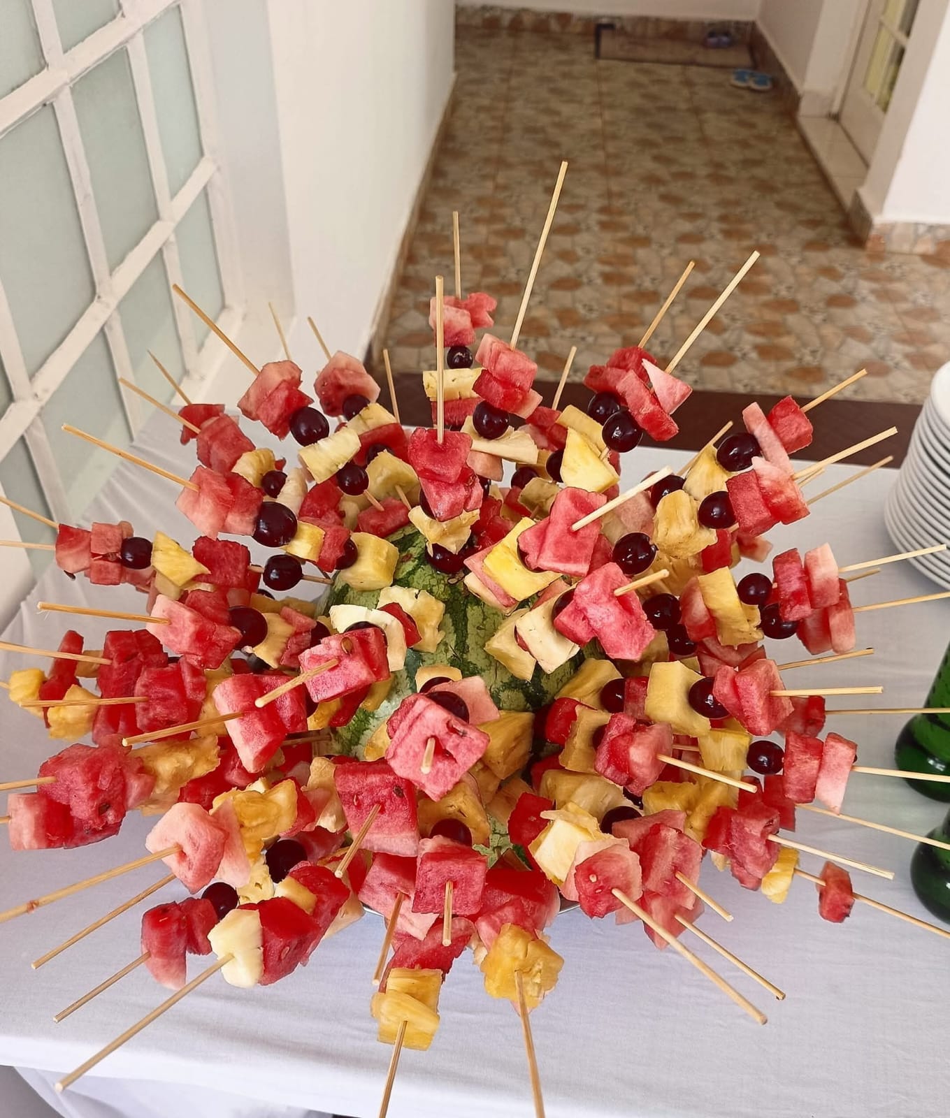 A watermelon centrepiece filled with fruit skewers on a set table at Vipe Fun Park